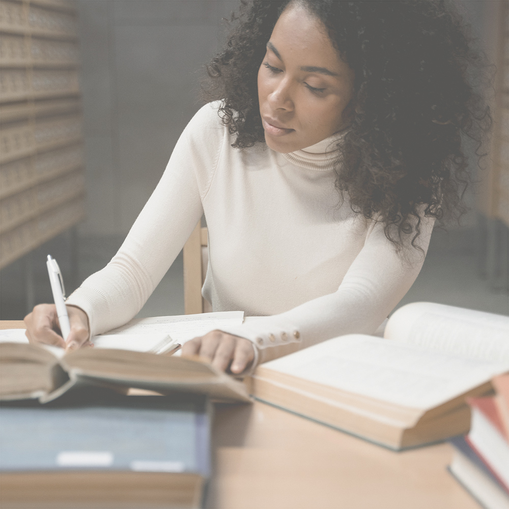 A woman studying with several textbooks